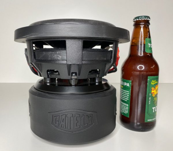 A bottle of Gately Audio Relentless 6.5 Inch Subwoofer next to a speaker.