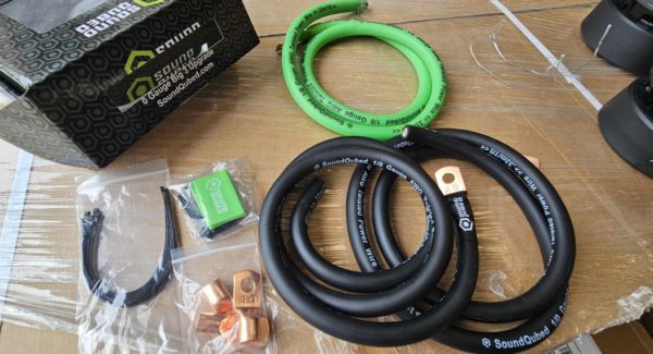 A Soundqubed 1/0 Big 3 - Underhood Electrical Wiring Upgrade Kit set of hoses and cables on a table.