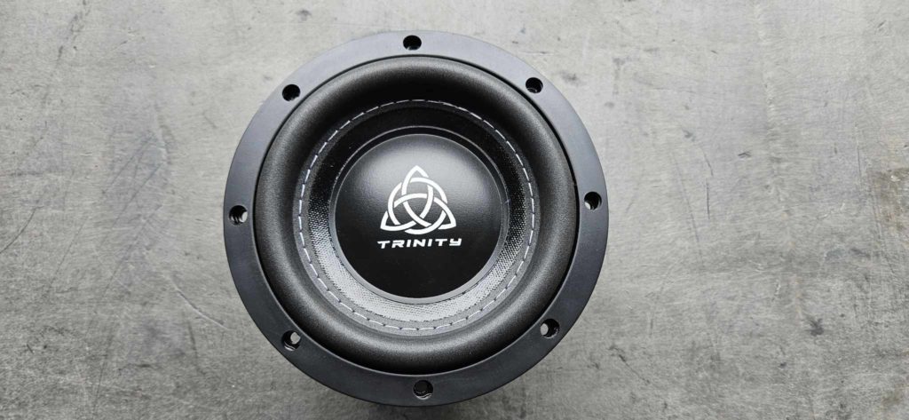 A BSTOCK - Trinity Audio Solutions TAS-M65 D2 speaker with a logo on it.