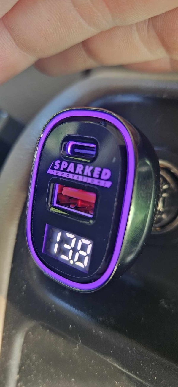 A Sparked Innovations 12v USB 4.0 Quick Charge 3.0 Power Delivery Voltmeter 60w charger with a purple light on it.
