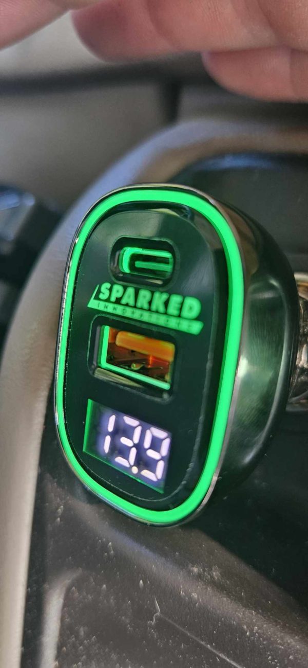 A Sparked Innovations 12v USB 4.0 Quick Charge 3.0 Power Delivery Voltmeter 60w with a green light on it.