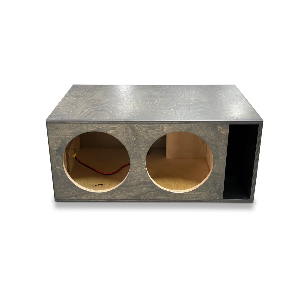 A high-performance subwoofer enclosure, crafted from wood and featuring two holes designed for the Adire Audio Performance Series – Dual 12″ 4.0 Cf Net Ported Enclosure v2.