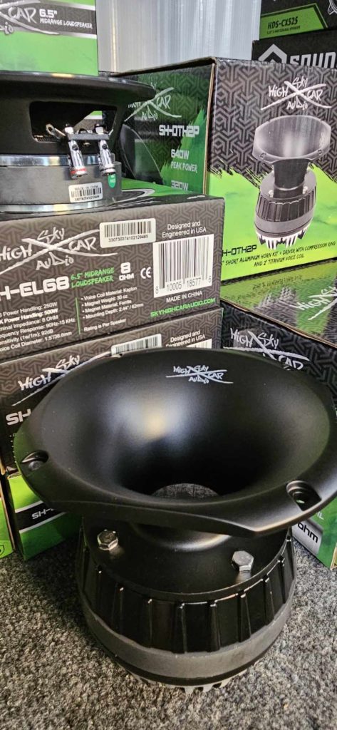 A black cone of Sky High Car Audio 2-inch Titanium Horn Driver SH-DTH2P speaker with products behind