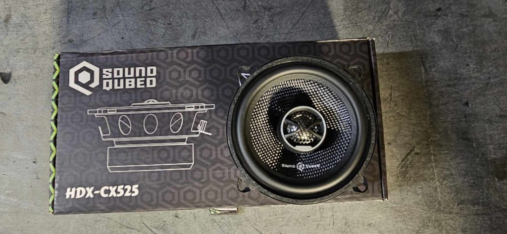 An Open Box - Soundqubed HDS-CX525 5.25 Inch Coaxial Speakers on a concrete floor.